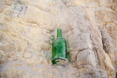 High angle view of beer bottle on rock