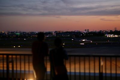 Woman standing on illuminated city at night