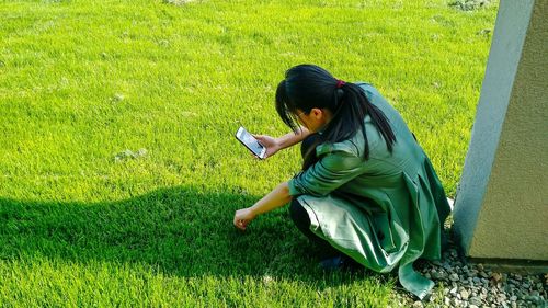 Woman using mobile phone on field