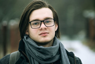 Young guy with glasses close-up face outdoors winter portrait