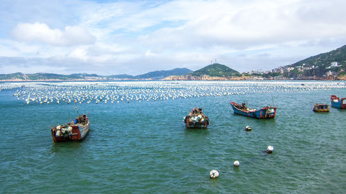 Boats in sea against sky