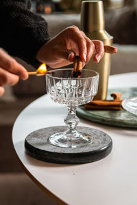 Close-up of hand holding wineglass on table