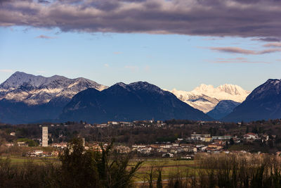 Townscape by mountains against sky