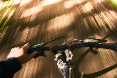 Close-up of man riding bicycle on road