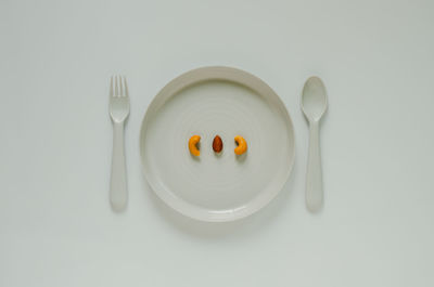 Cashew nut and almond on plate with fork and spoon. minimal creative healthy diet food concept.