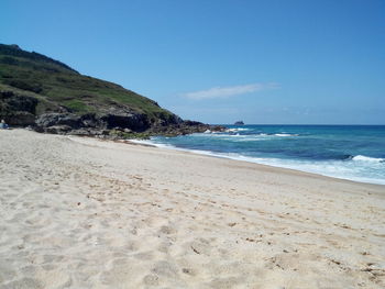 Scenic view of beach against blue sky