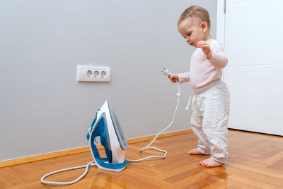 Full length of girl playing with toy on floor at home