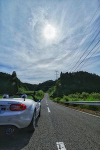 Cars on road against sky in city