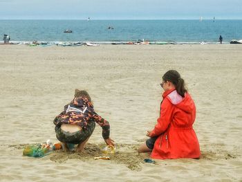 Full length of woman sitting on beach