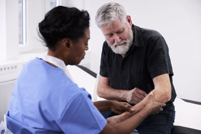 Female doctor examining patient's arm