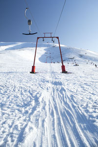 Ski lift on snowcapped mountain against sky