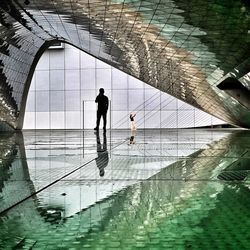 Digital composite image of people walking by swimming pool