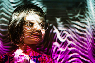 Close-up of girl looking away against abstract backgrounds