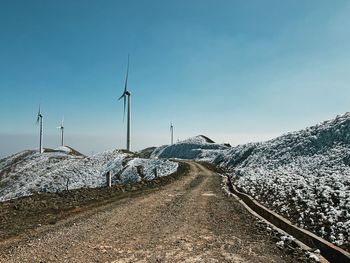 Road leading towards snowcapped mountain against sky