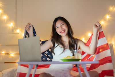 Portrait of smiling young woman using mobile phone