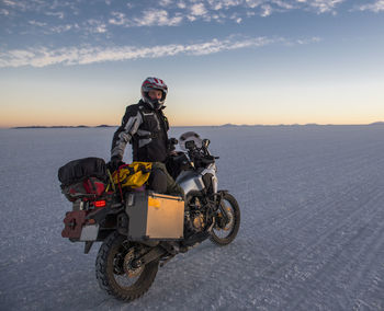 Man riding his touring motorbike on the salt flats of uyuni in bolivia