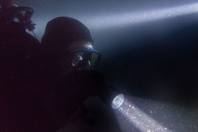 Close-up of man photographing illuminated light