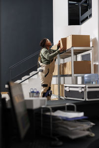 Side view of man using mobile phone while standing in office