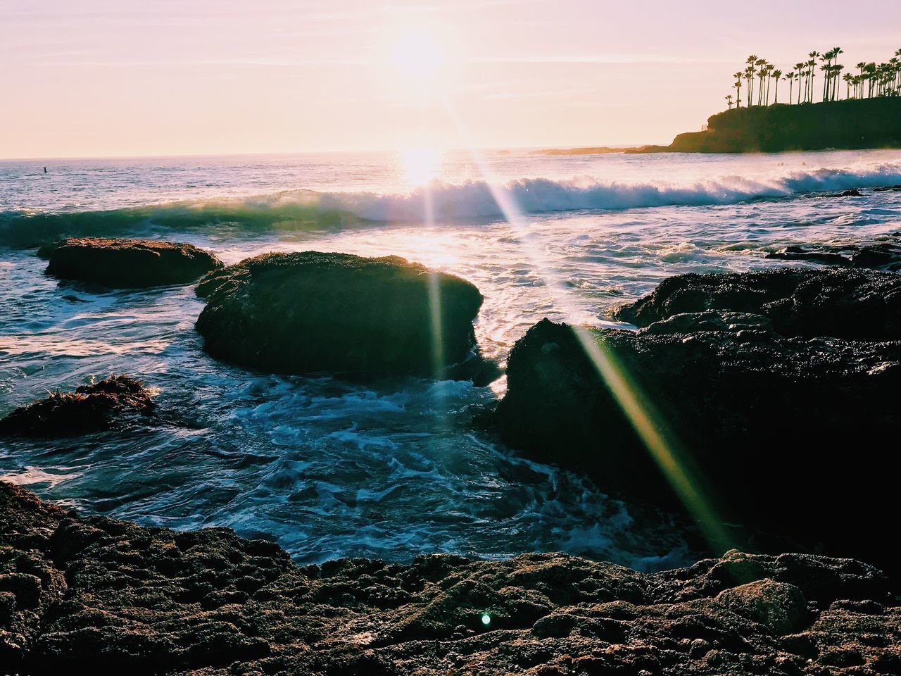 SEA WAVES SPLASHING ON ROCKS AGAINST SKY