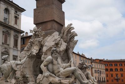 Low angle view of statue against buildings