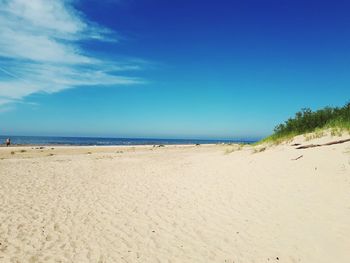 Scenic view of beach against blue sky