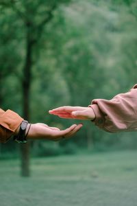 Midsection of people with hands against blurred background