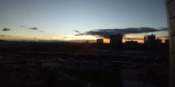 View of city street against sky during sunset