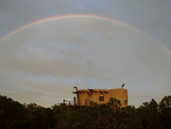 Scenic view of rainbow over houses