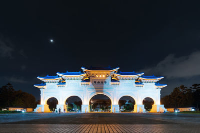 Illuminated building against sky at night