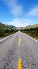 Surface level of road amidst mountains against sky