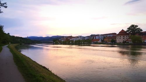 Scenic view of river by town against sky