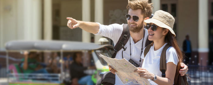 Young couple holding sunglasses in city