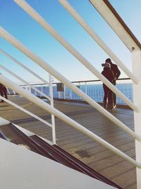 Rear view of man and woman walking on railing