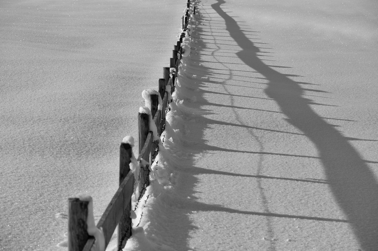 HIGH ANGLE VIEW OF EMPTY ROAD ALONG SNOWED LANDSCAPE