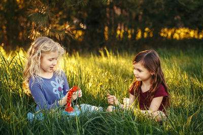 Friends playing with dolls on field