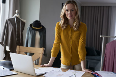 Portrait of young woman using laptop at office