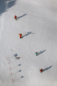 High angle view of people skiing on snow covered field