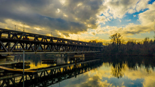 Bridge over river against sky during sunset