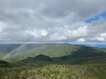 Scenic view of rainbow over land against sky