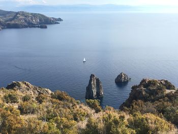 High angle view of rocks by sea against sky