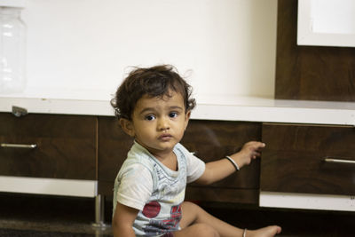 A small child looking at the camera, indoors portrait