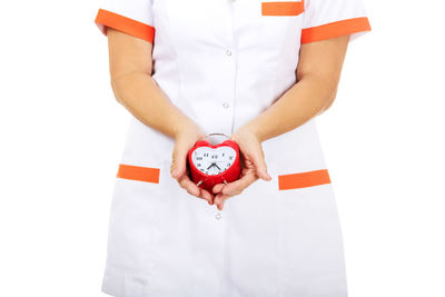 Midsection of woman holding umbrella standing against white background