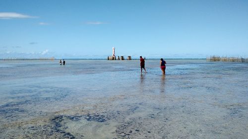 People on beach against sky
