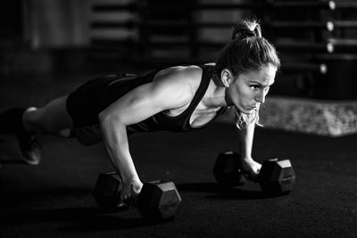 Cross training. young woman exercising with dumbbells