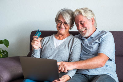 Young woman using mobile phone while sitting on sofa at home