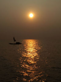 Silhouette boat in sea against sky during sunset