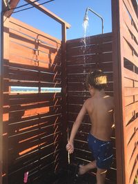 Boy taking a shower outdoors