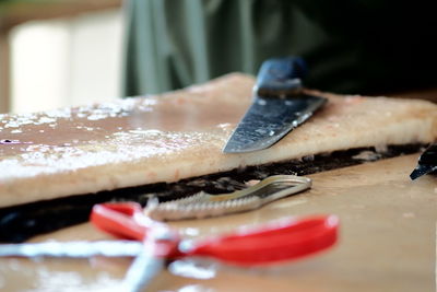 Close-up of knife on cutting board at table