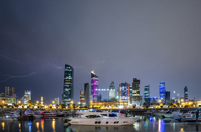 Illuminated buildings in city against sky at night