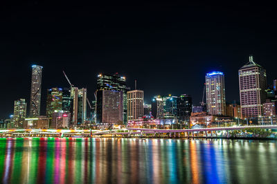 Illuminated buildings against sky at night